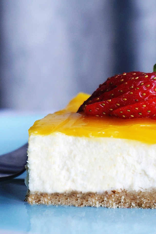 Кусок чизкейка с кремом и спелой клубникой 