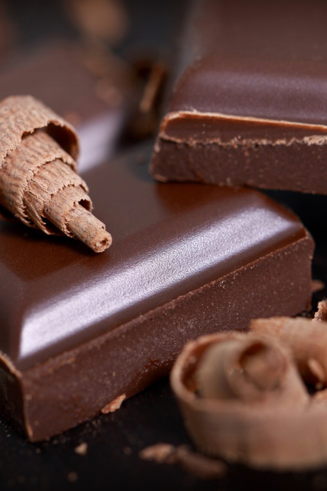 Куски шоколада и стружка на столе крупным планом