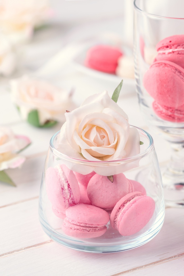 Розовый десерт макарон в вазе с розой