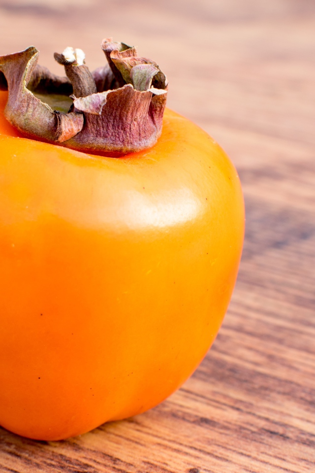 Спелая оранжевая хурма на столе