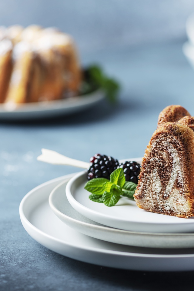 Кусочки кекса на тарелке с ягодами ежевики