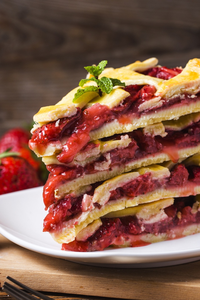 Пирог с ягодами клубники на белой тарелке 