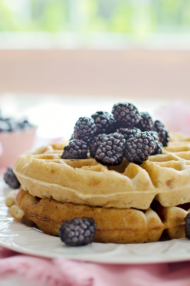 Сладкие вафли на белой тарелке с ягодами ежевики