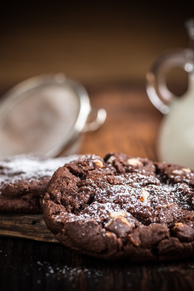 Вкусное шоколадное печенье с орехами на столе с молоком