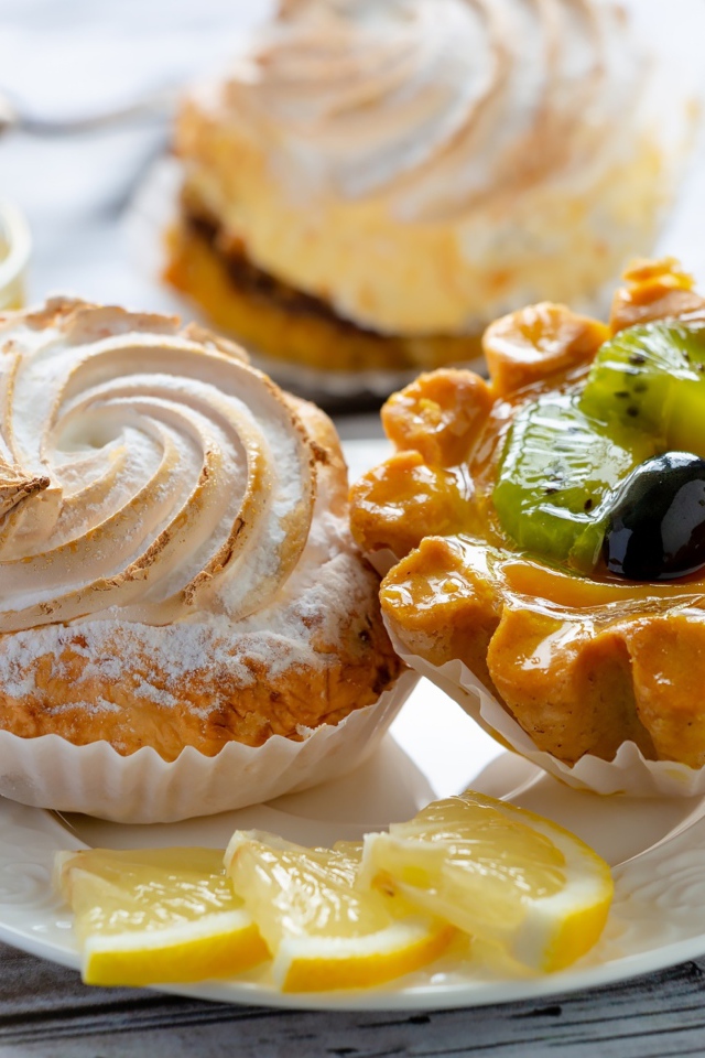 Вкусные аппетитные пирожные на тарелке с лимоном