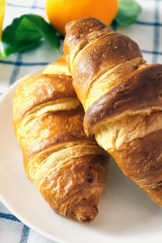 Два круассана на столе с джемом и соком