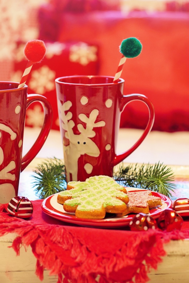 Две красные чашки с печеньем на столе на Рождество 