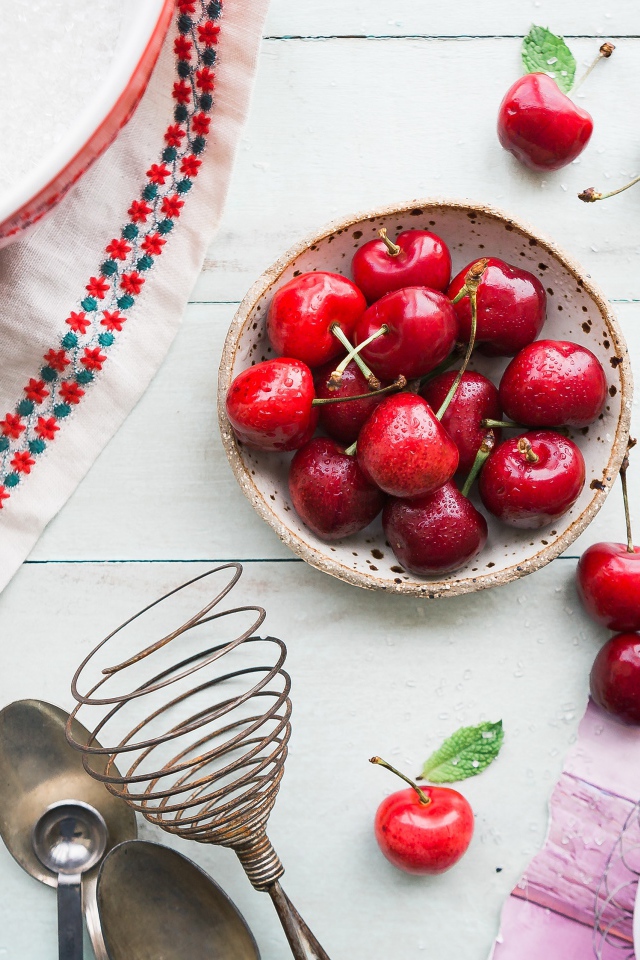 Мокрые ягоды черешни на столе с пирожным