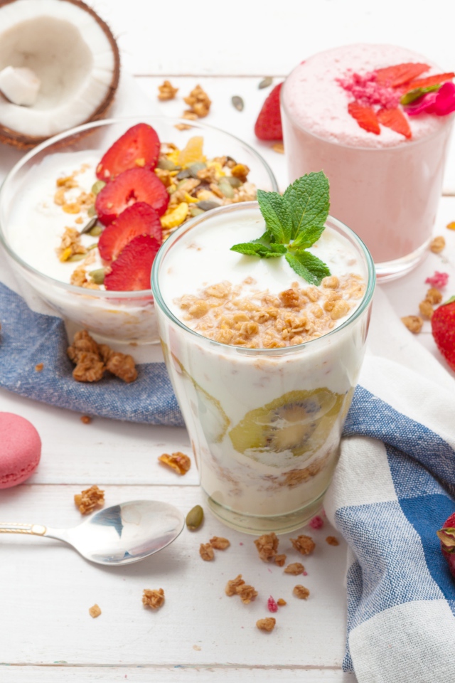 Йогурт с хлопьями и ягодами клубники на столе 