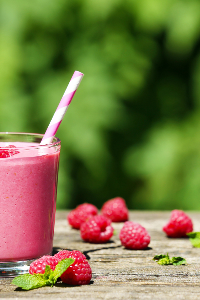 Коктейль в стакане с трубочкой и ягодами малины