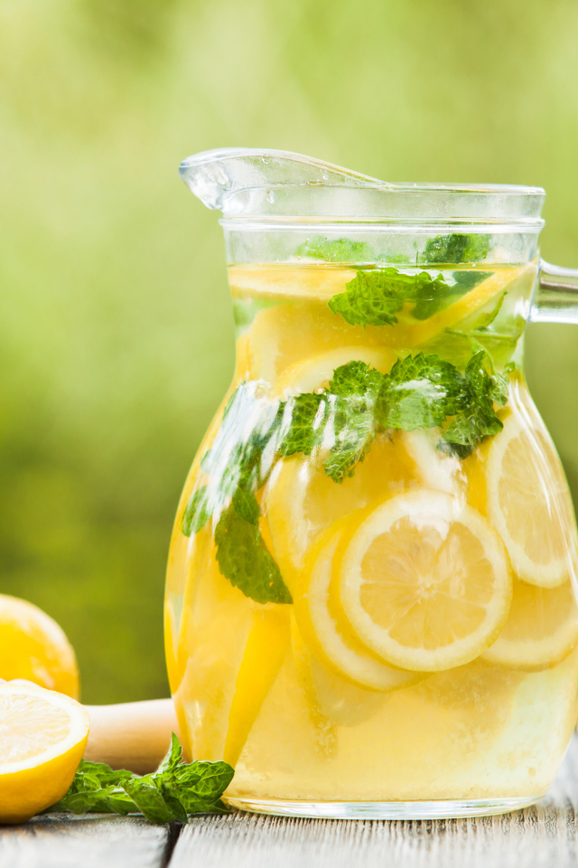 Лимонад в графине на столе с лимонами