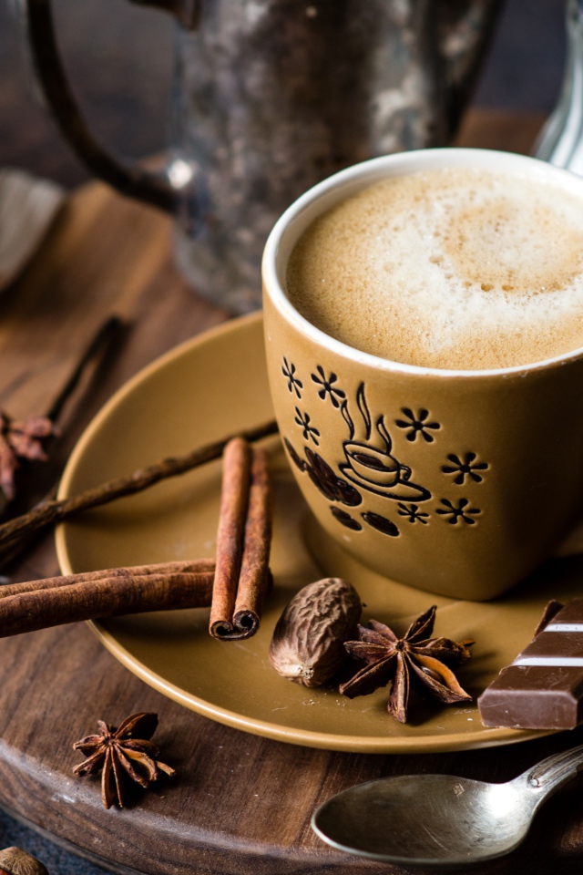 Чашка капучино на блюдце со специями