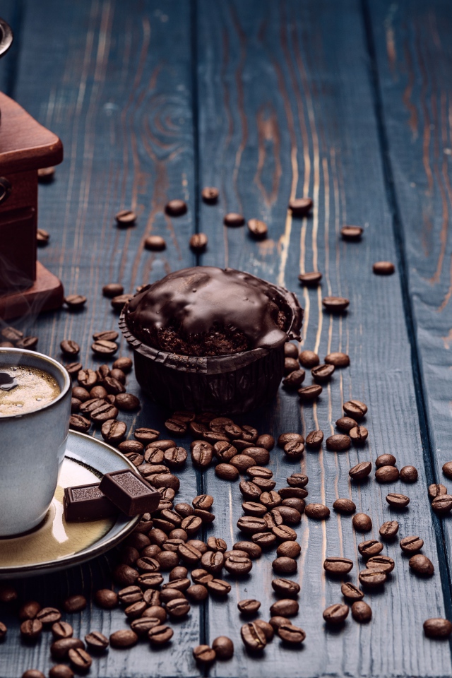 Чашка кофе на столе с шоколадным кексом и кофемолкой