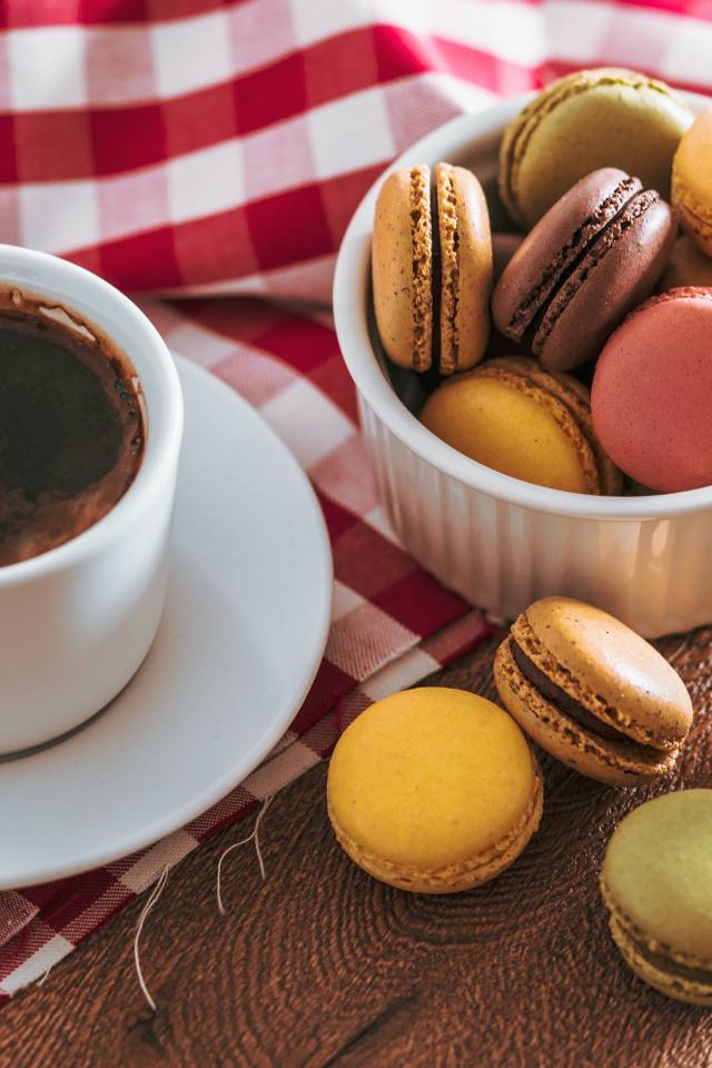 Чашка кофе на столе с десертом макарун 