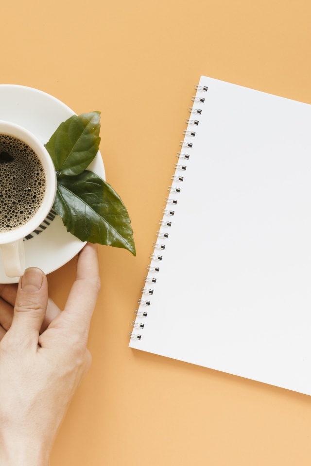 Чашка кофе на столе с блокнотом