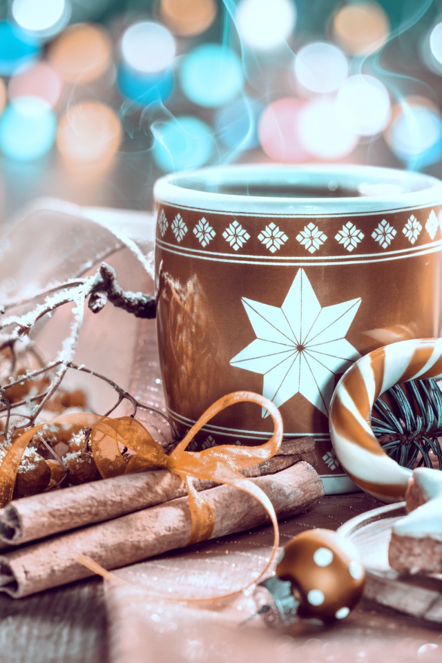 Чашка горячего кофе на столе с корицей и печеньем и веткой рябины