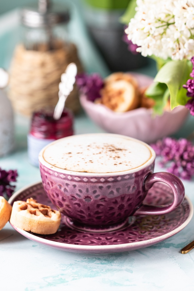 Чашка вкусного кофе с печеньем на столе с букетом сирени