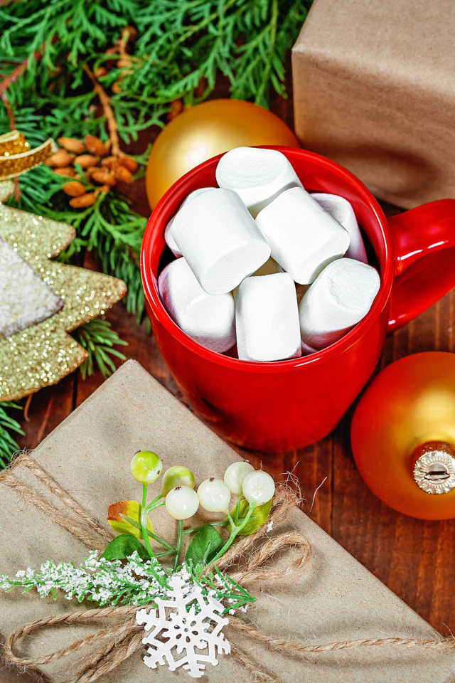 Чашка с маршмеллоу на столе с подарком, печеньем и еловой веткой