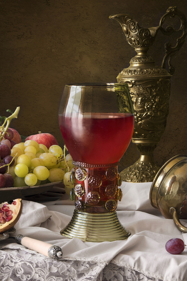 Кубок с вином на столе с фруктами