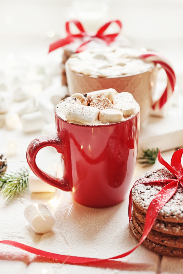 Чашки напитка с маршмеллоу на столе с печеньем