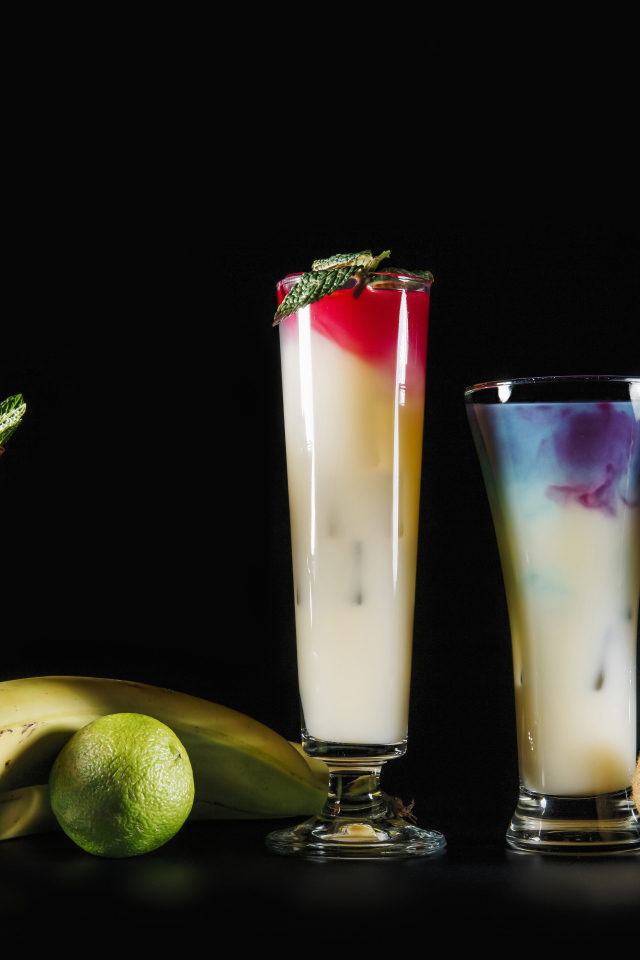 Вкусные тропические коктейли на черном фоне с фруктами