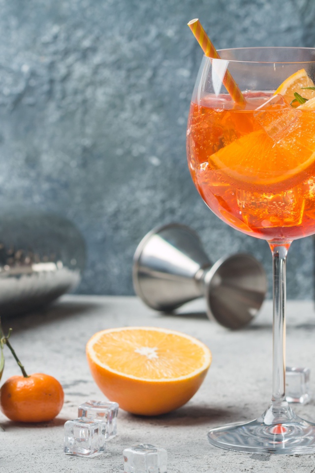 Напиток в бокале со льдом и кусочками апельсина 