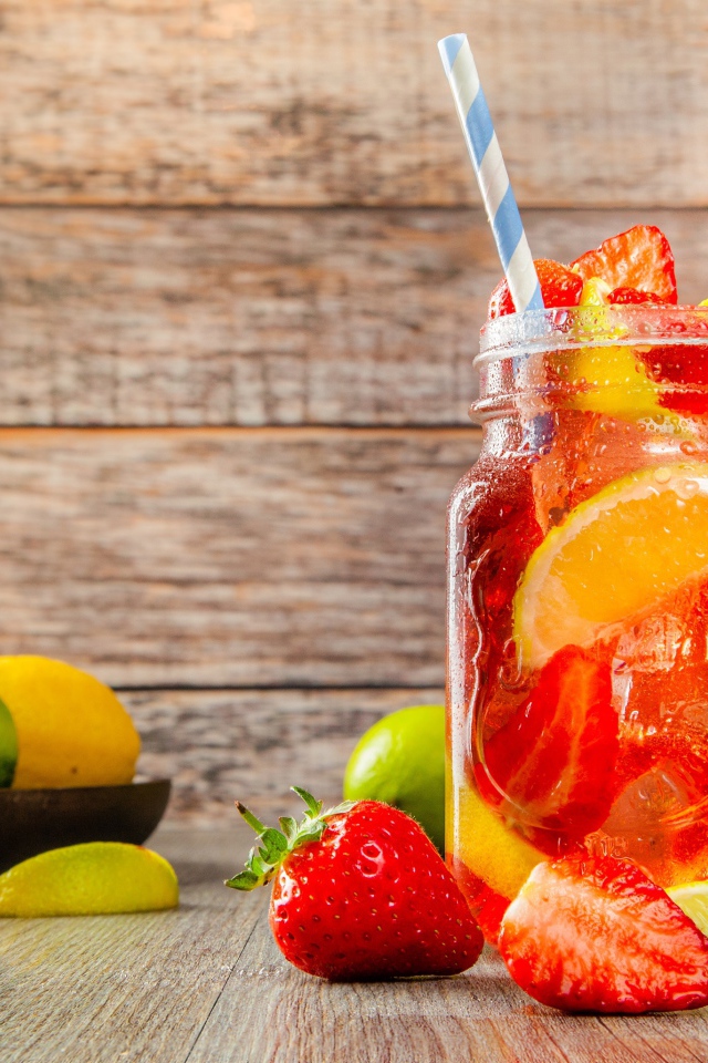 Напиток с клубникой и лимоном в банке на столе 