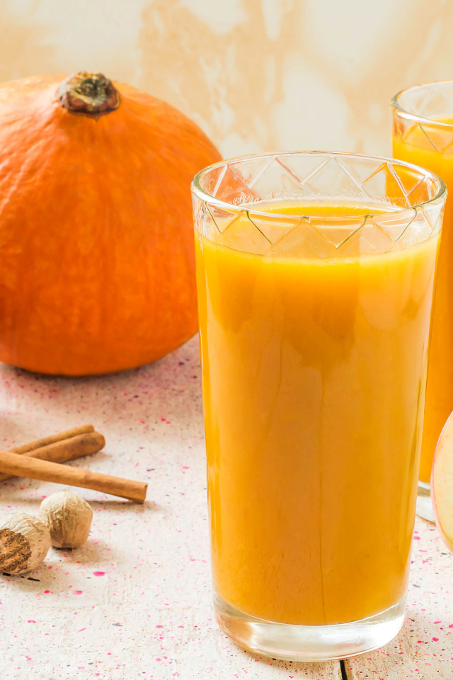 Свежевыжатый сок в стаканах на столе с фруктами