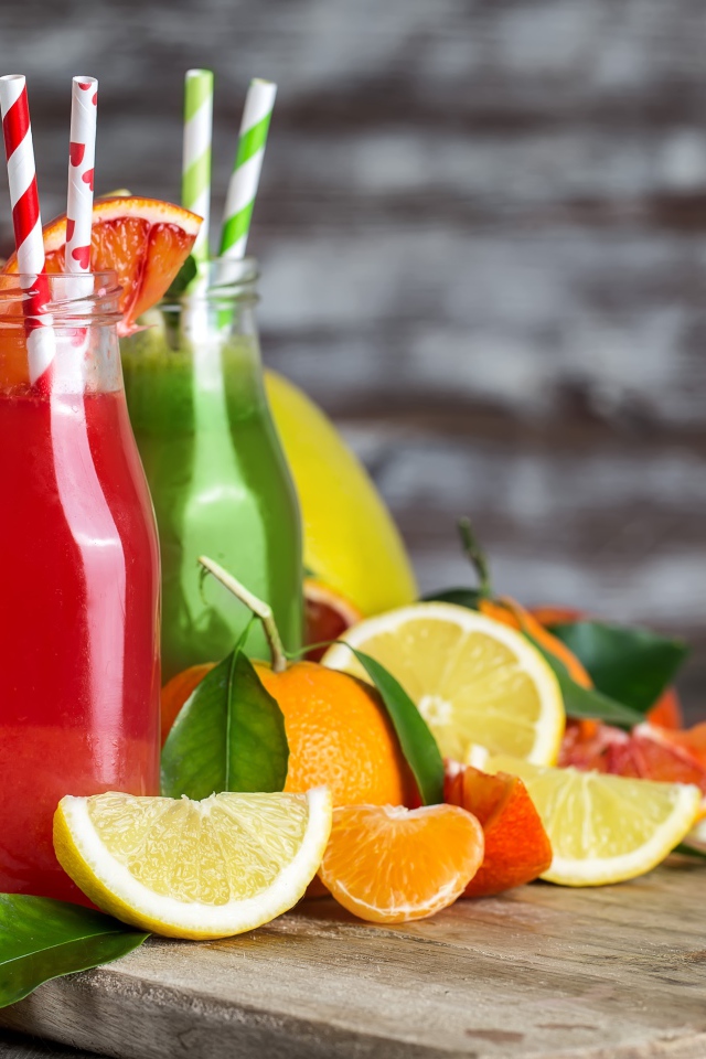 Фруктовое смузи на столе в бутылках с трубочками