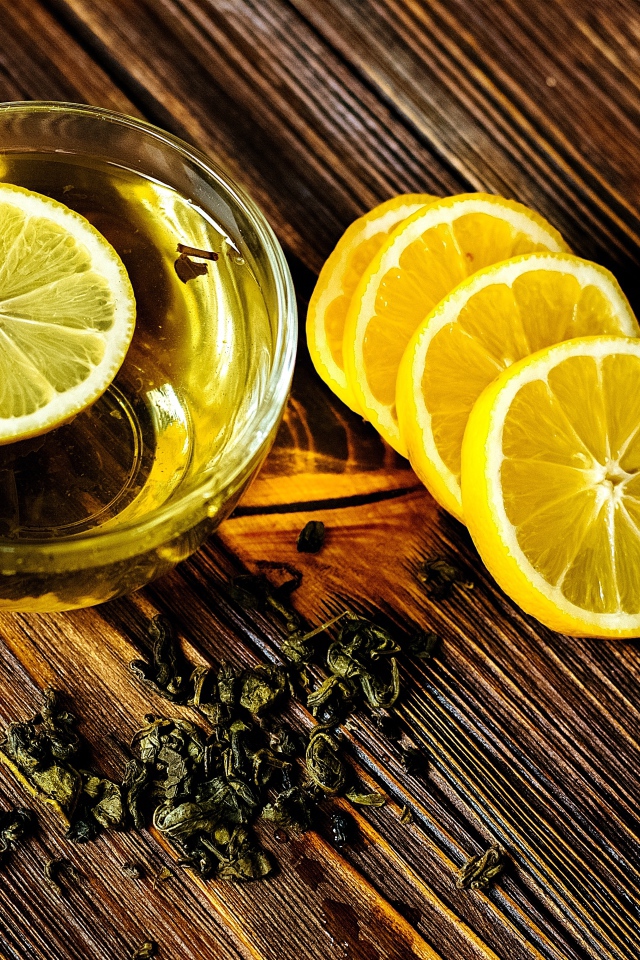 Зеленый чай в стеклянной чашке с лимоном