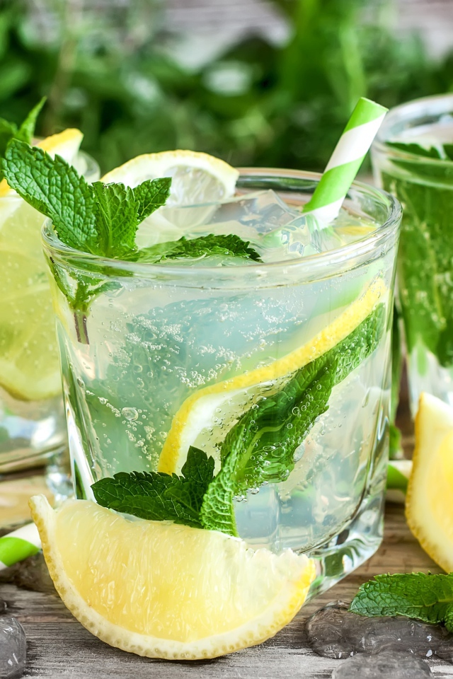 Лимонад с мятой и кусочками лимона в стаканах на столе