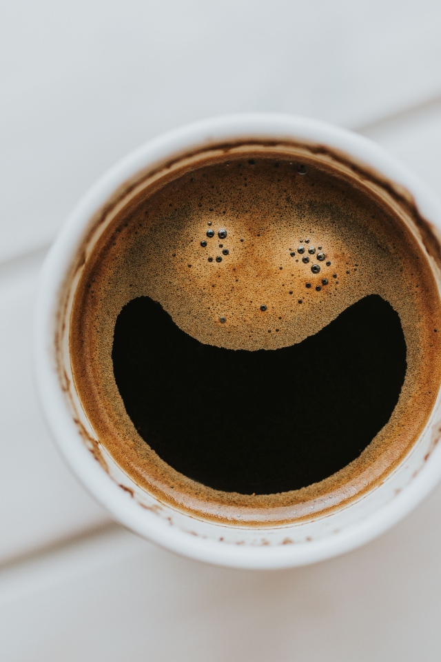 Улыбка на кофейной пенке в белой чашке