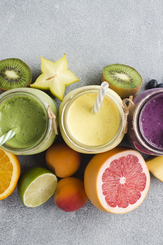 Смузи в банках на столе в ягодами и фруктами