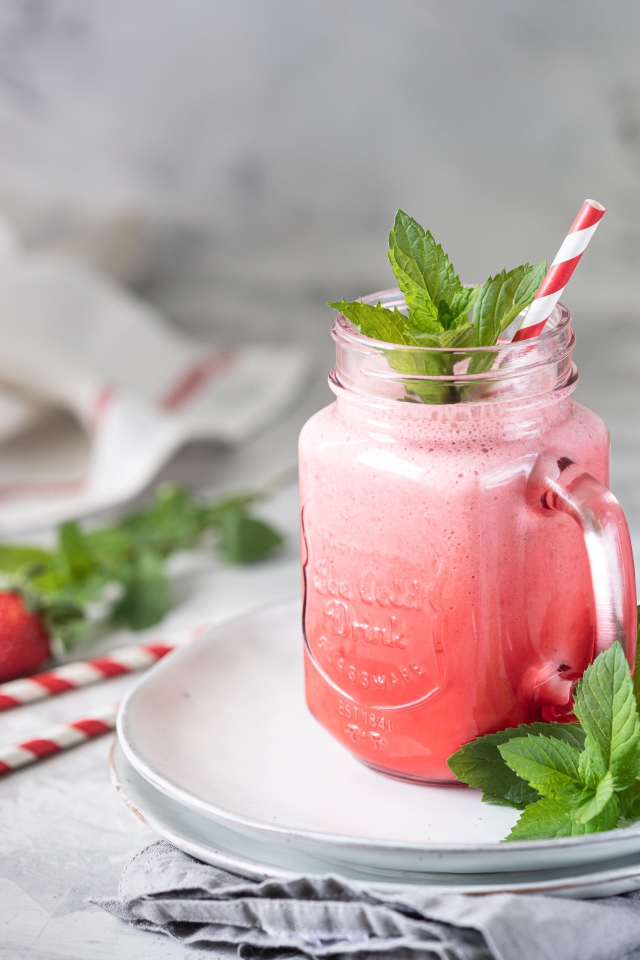 Смузи с клубникой в банке с трубочкой и листьями мяты