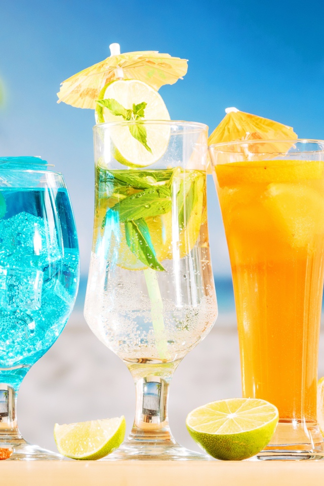 Три вкусных тропических коктейля стоят на пляже