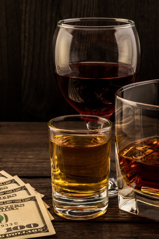 Три сосуда  с виски на столе с долларами