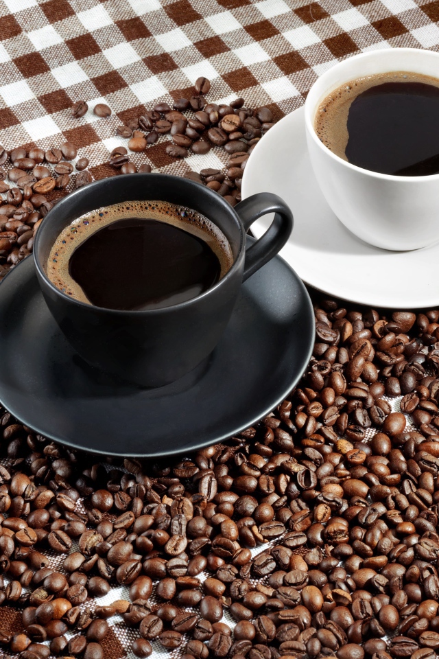 Две чашки ароматного кофе на скатерти с зернами