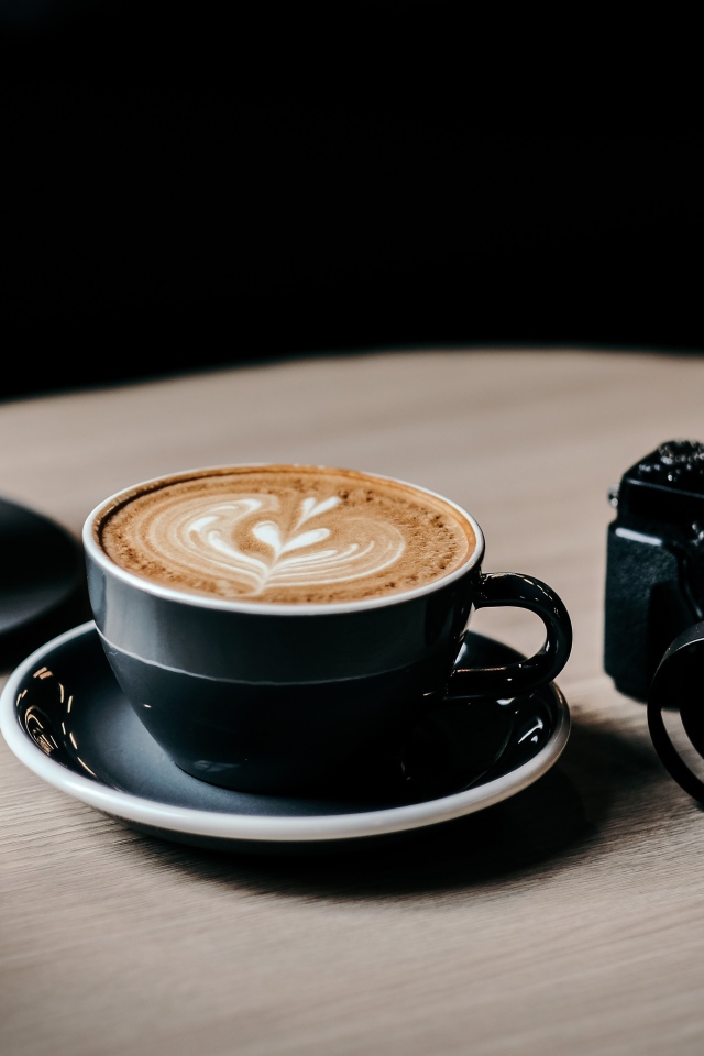 Две чашки кофе на столе с фотоаппаратом 