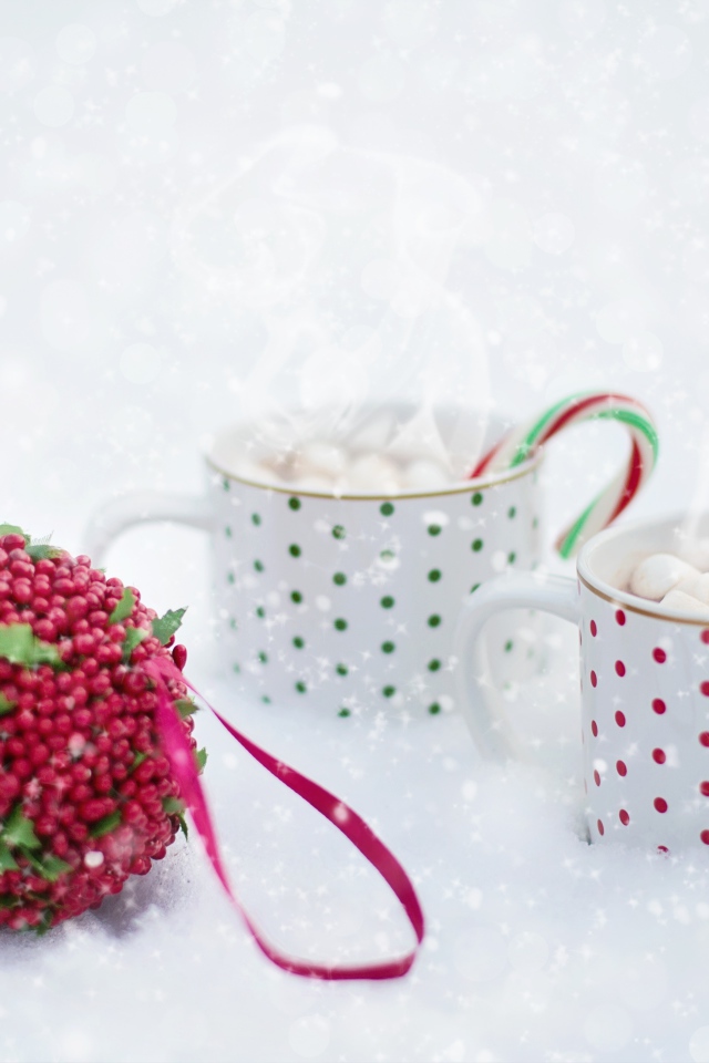 Две чашки горячего какао с маршмеллоу на снегу 