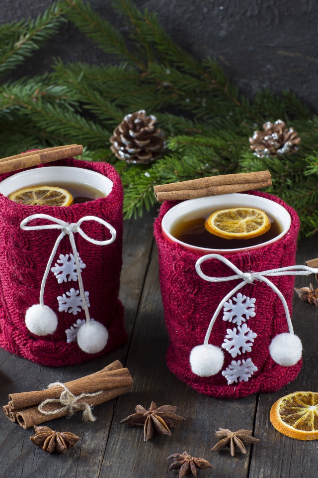 Две чашки горячего чая с лимоном на столе с еловыми ветками