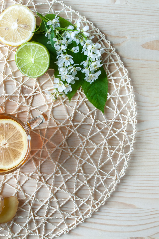 Две чашки чая с лимоном на плетеной подставке 