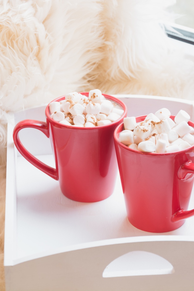 Две красные чашки с маршмеллоу у окна