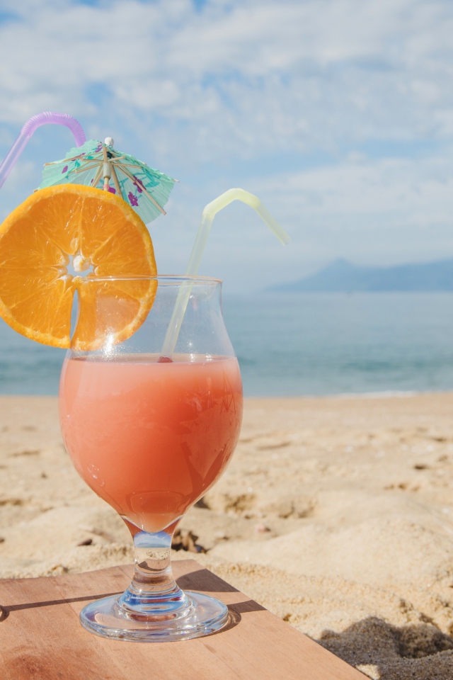 Два тропических коктейля на пляже в лучах солнца