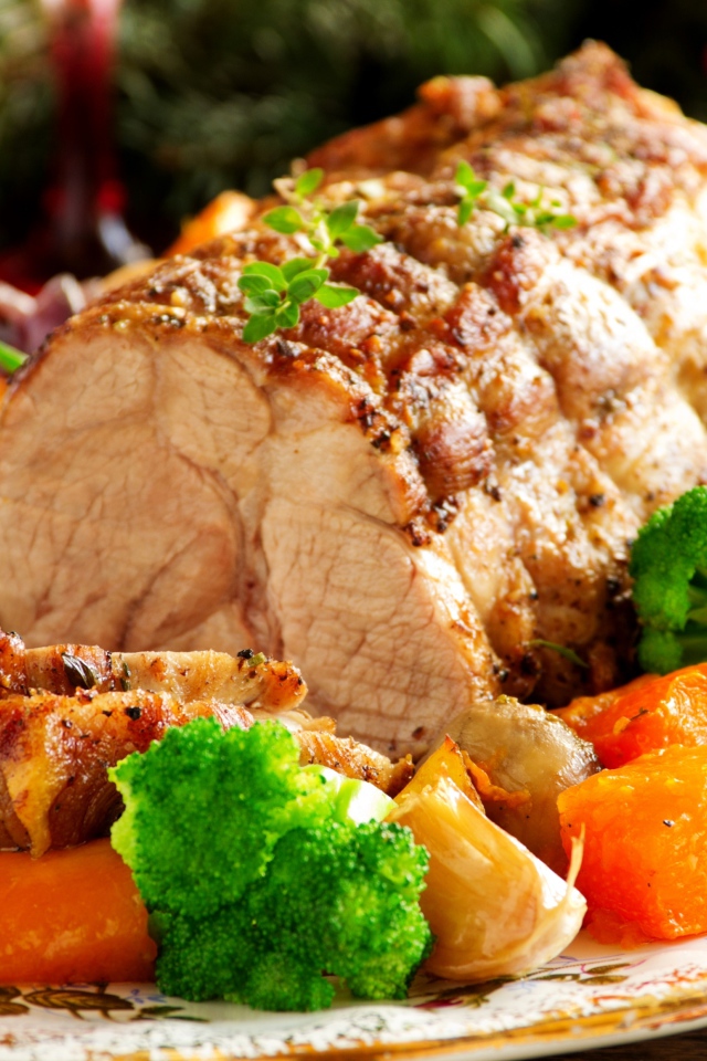 Кусок запеченного мяса на тарелке с овощами