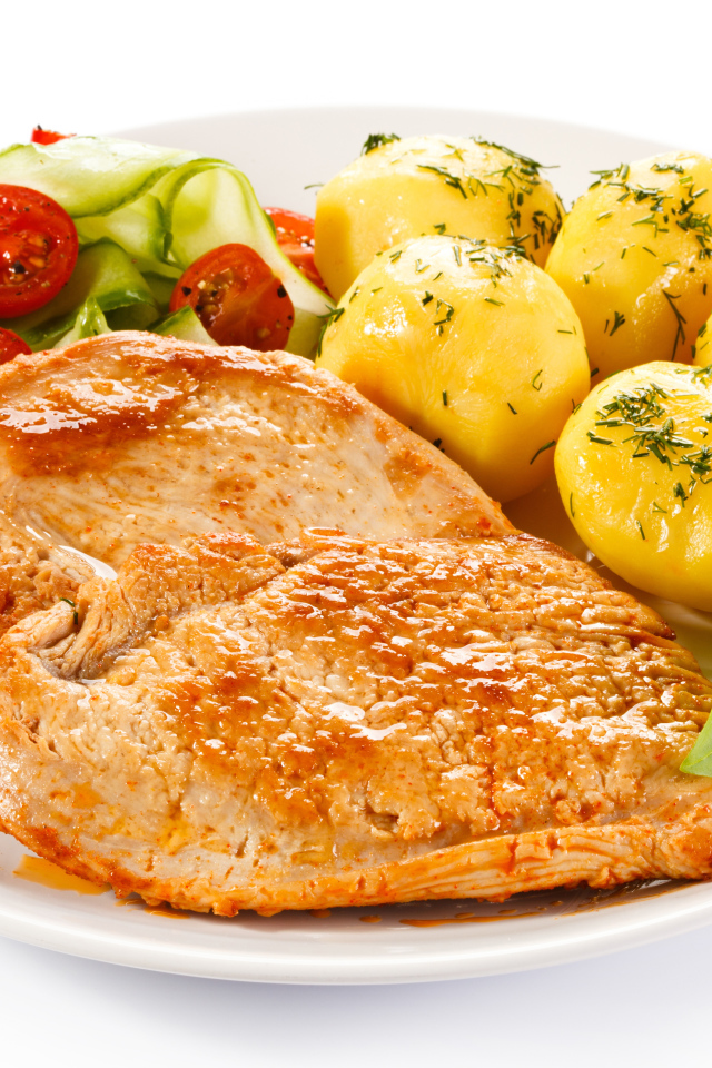 Кусок сочного куриного мяса на тарелке с картофелем и салатом