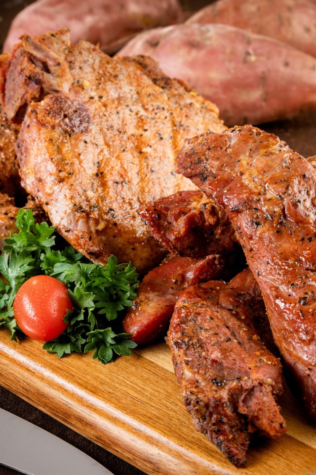 Аппетитное запеченное мясо на столе с чесноком и картофелем