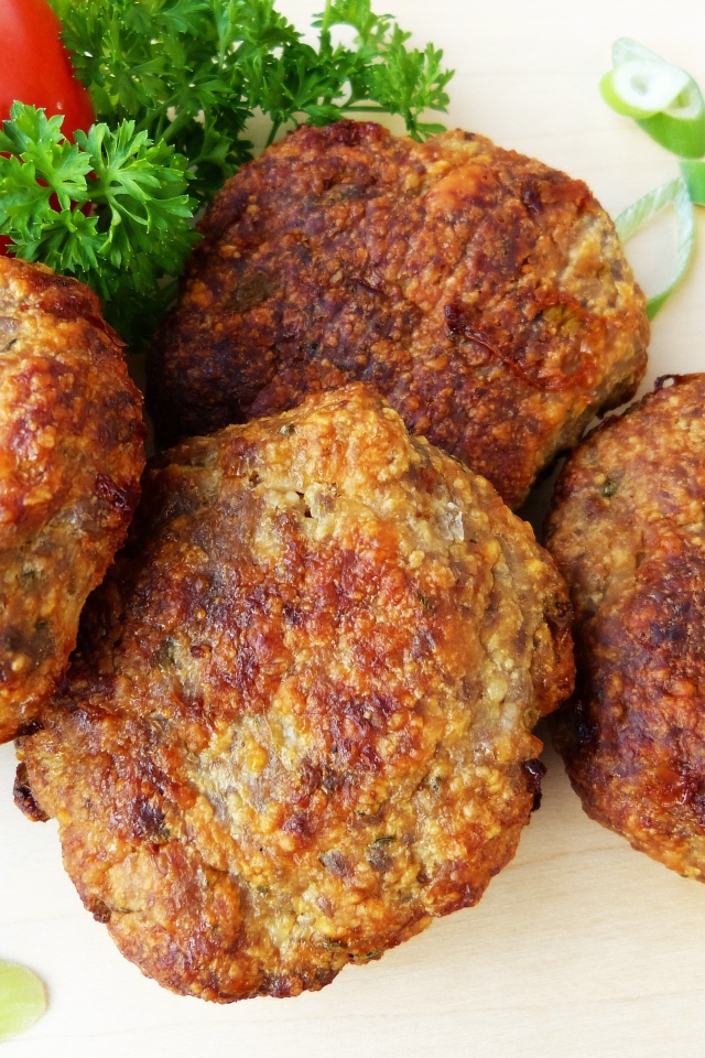 Аппетитные котлеты на тарелке с помидорами и петрушкой