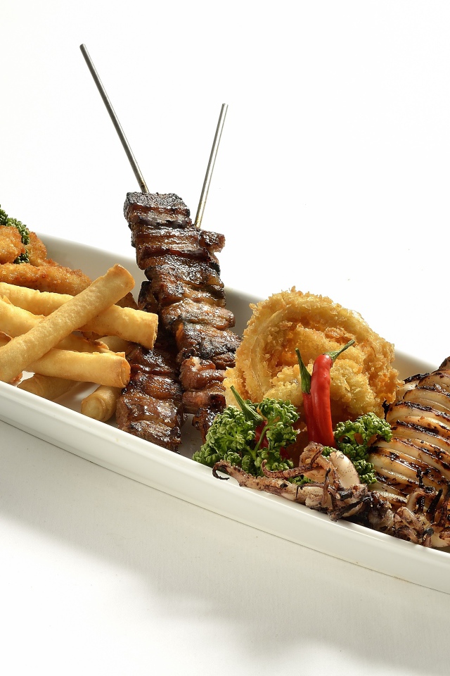 Мясо барбекю на тарелке с морепродуктами в кляре