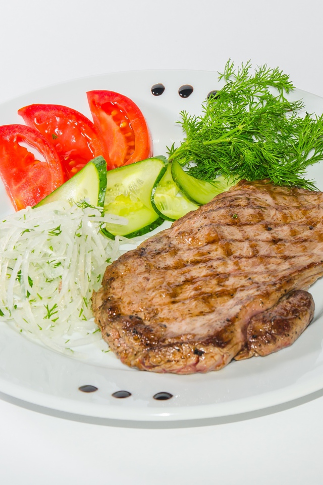 Кусок курицы с овощами на белой тарелке 