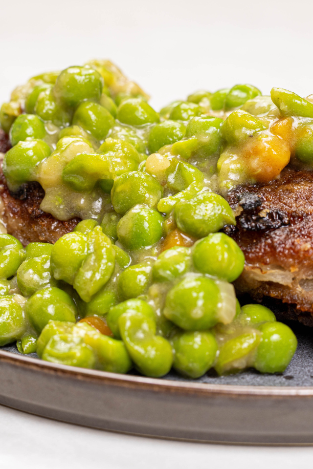 Котлета на тарелке с зеленым горошком